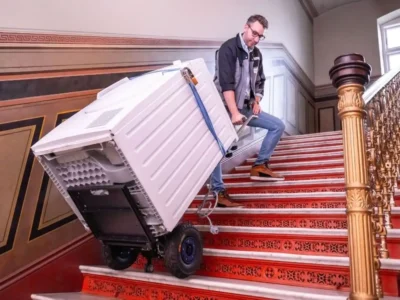 Transport einer Waschmaschine über eine Treppe mit der elektrischen Treppensackkarre.