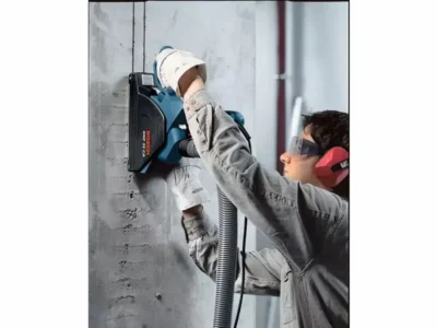 Bosch Mauernutfräse GNF35 mit Staubabsaugung beim Schlitzen einer Betonwand.