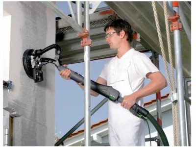 Die Festool "Planex" ohne Verlängerung beim Wandschleifen auf einem Gerüst.